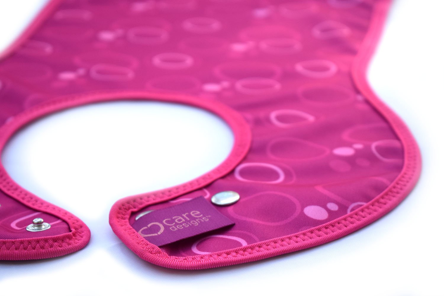 Care Designs- Junior Bib- Detail view- Pink ellipses- 72dpi